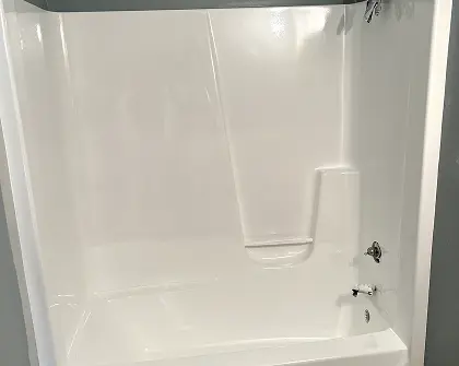 Bathtub and shower surround after professional reglazing in Lindenhurst ,NY — bright white like-new finish